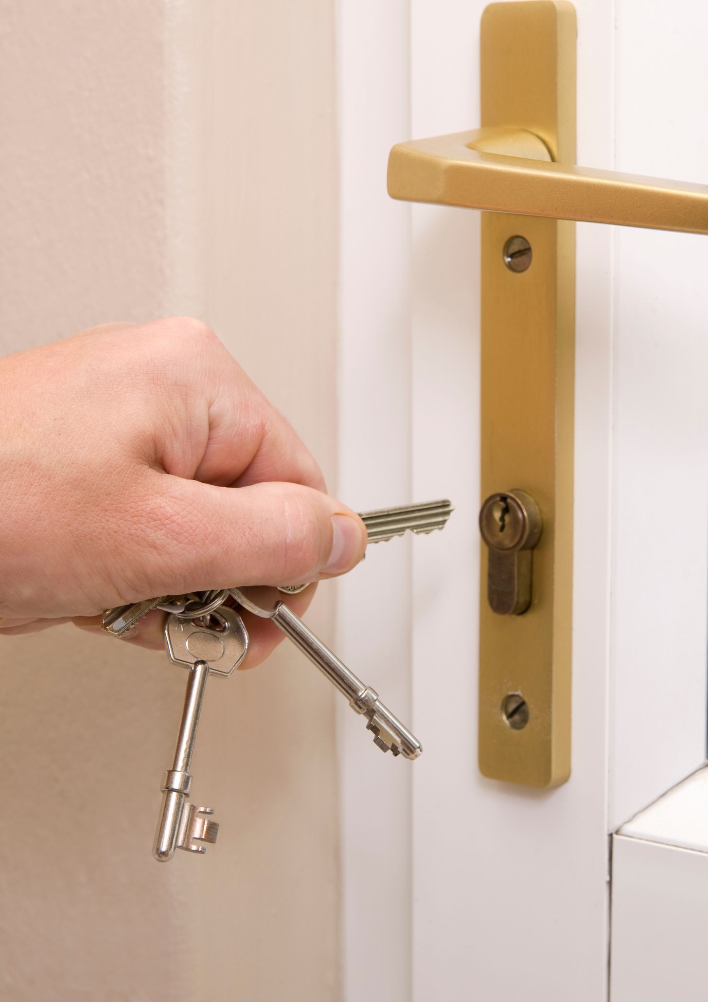 A person is opening a door with keys in their hand.