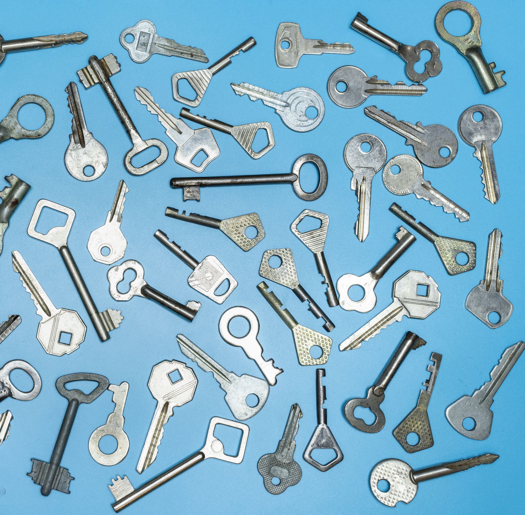 A bunch of keys are laying on a blue surface