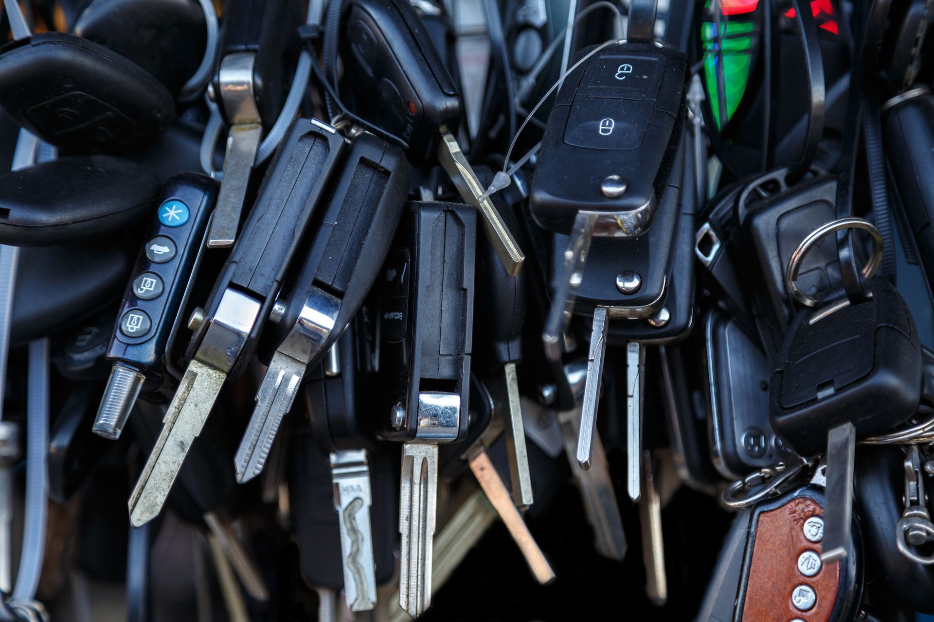 A bunch of car keys are stacked on top of each other.