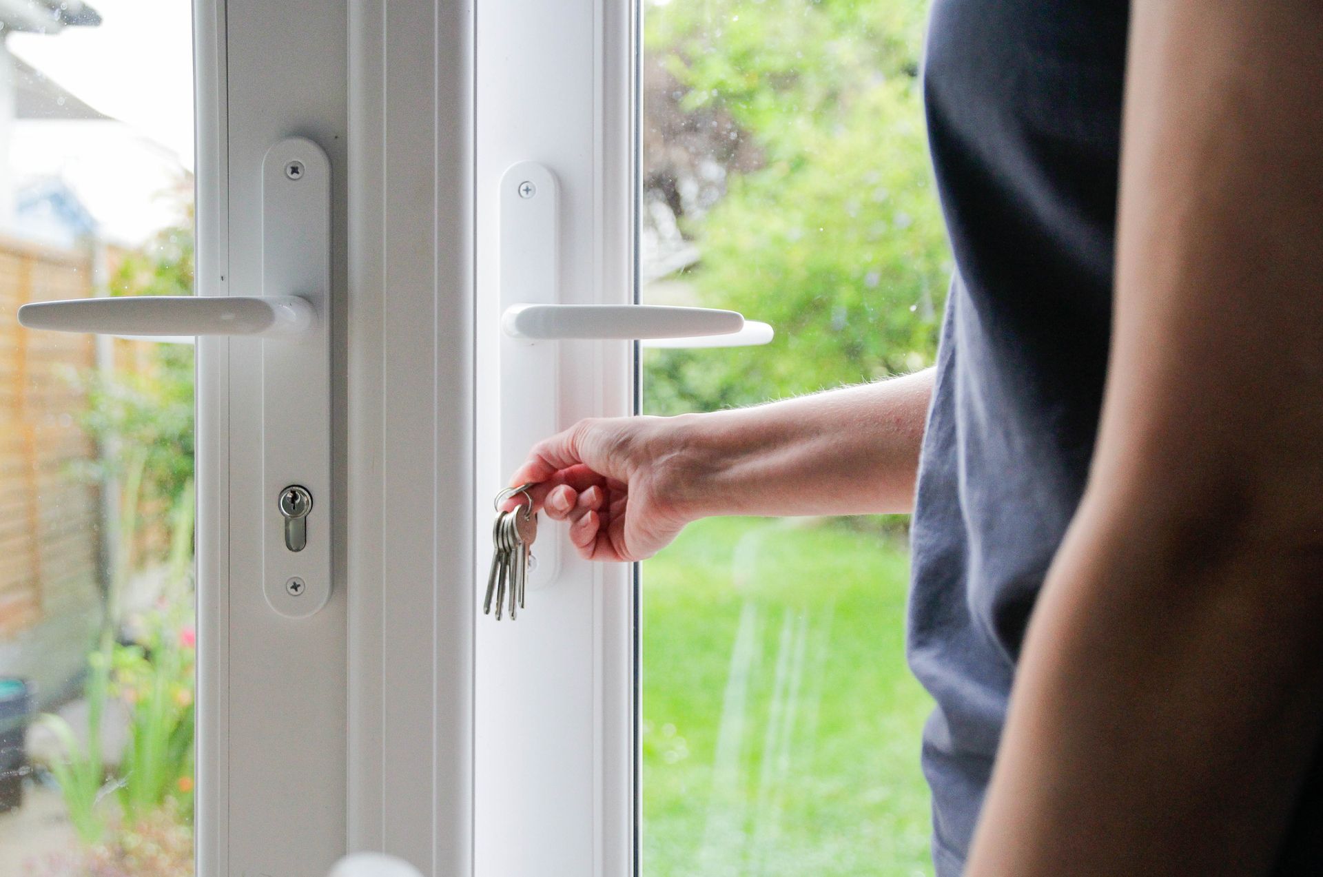 A woman is opening a door with keys in her hand.