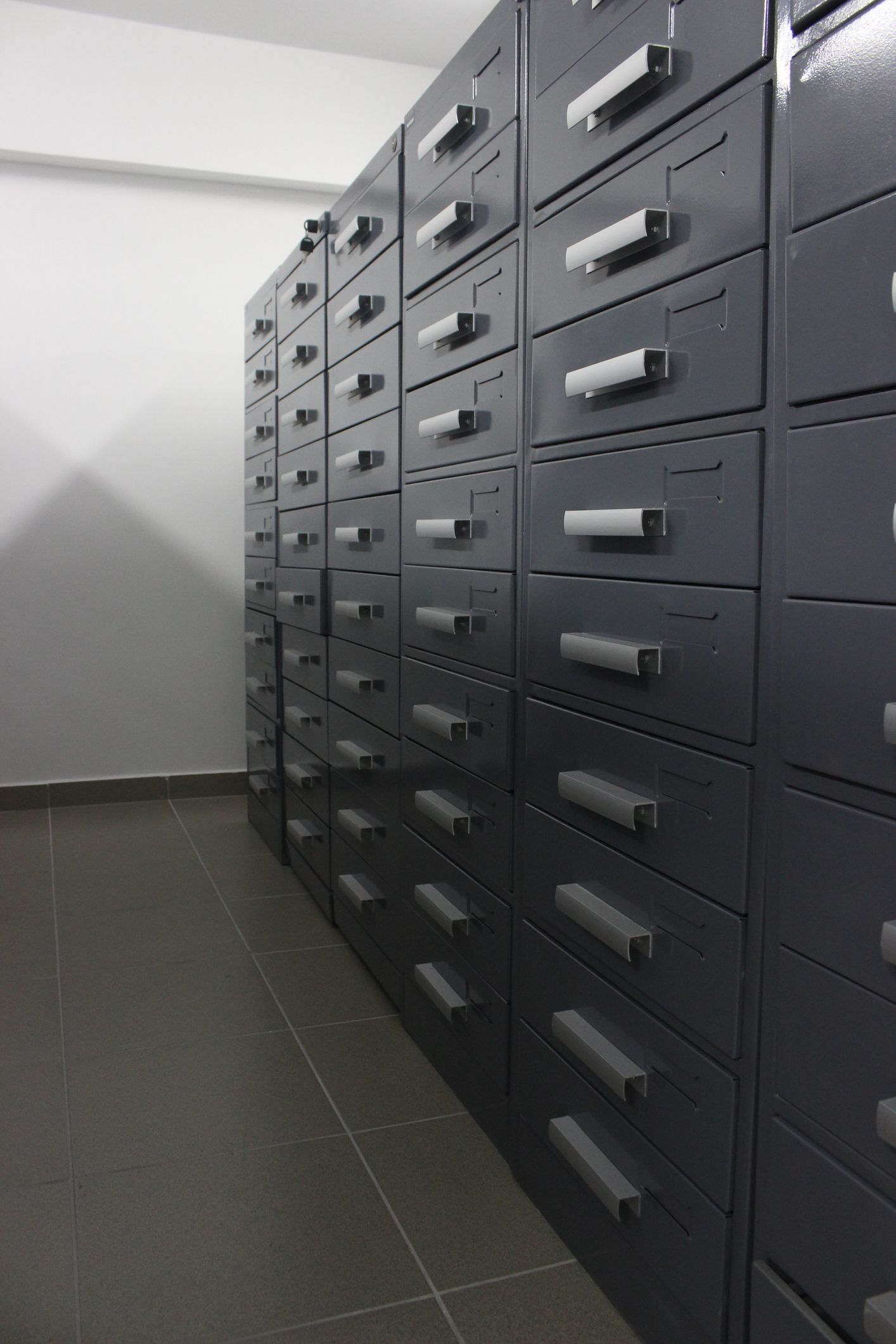 A row of filing cabinets with lots of drawers in a room