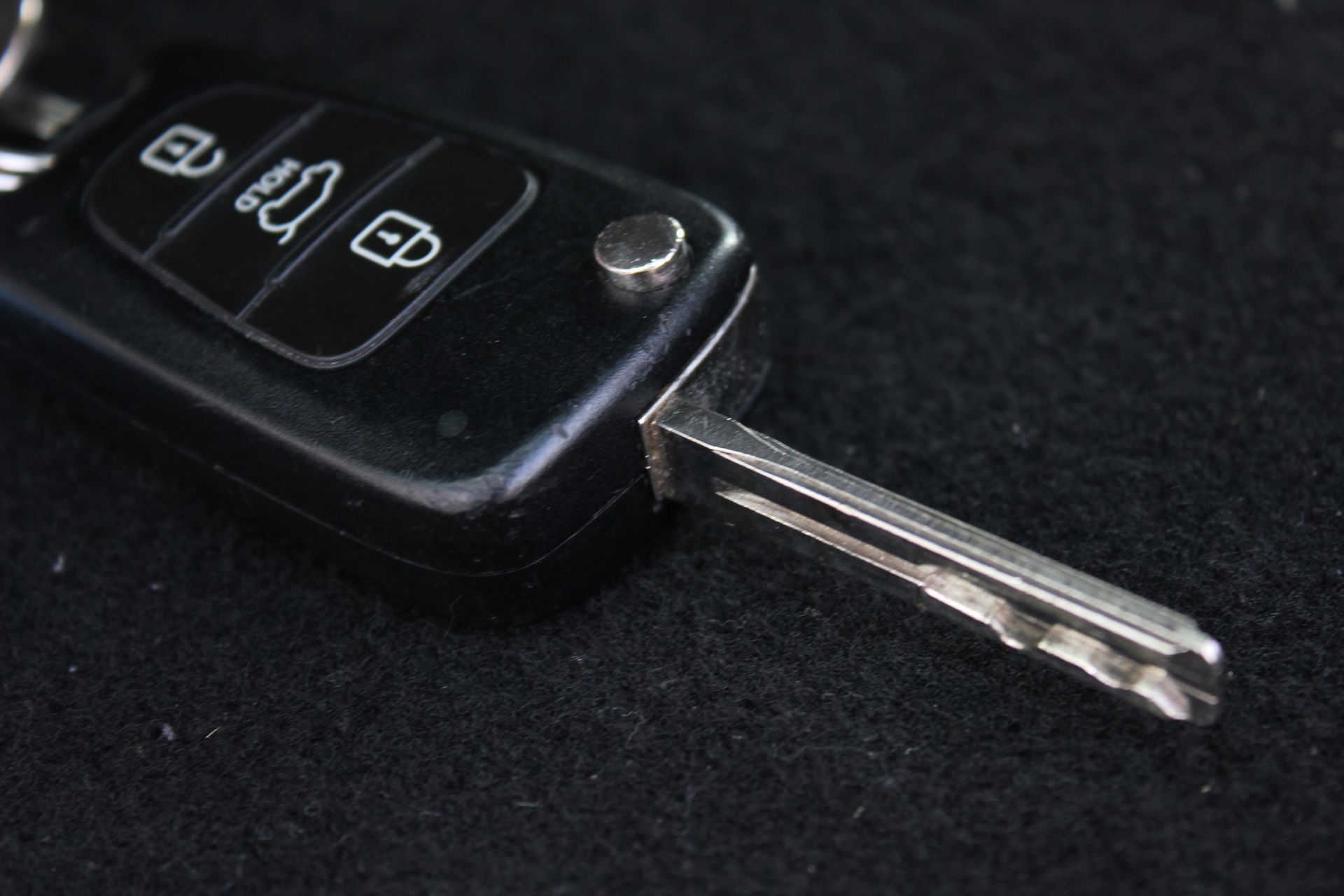 A close up of a car key on a black surface