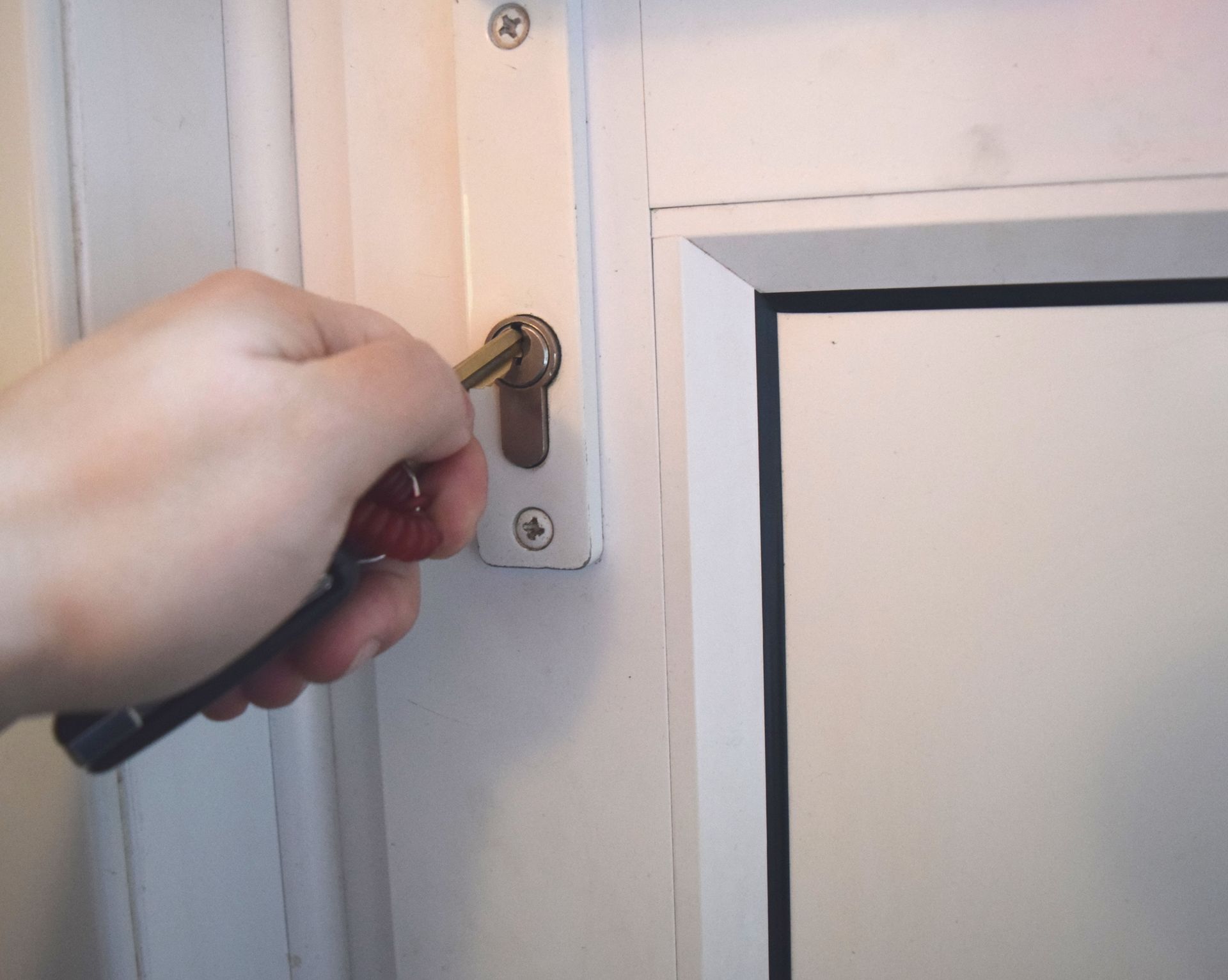 A person is opening a door with a key.