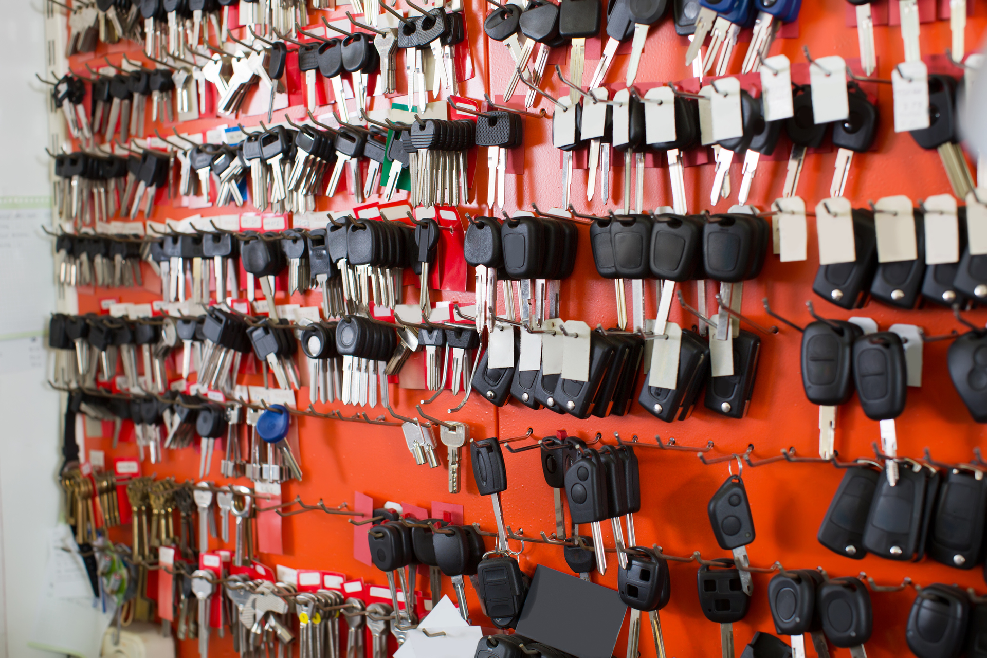 A bunch of keys are hanging on a wall in a locksmith shop.