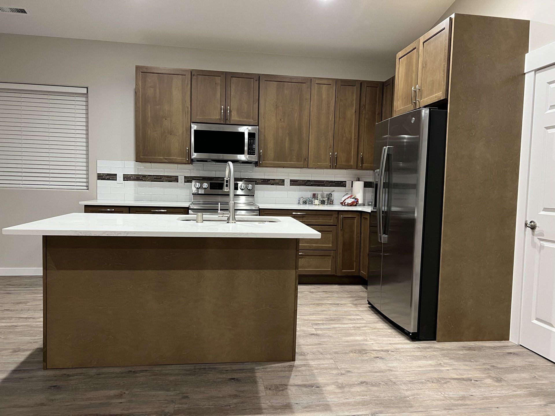 Modern kitchen with wood cabinets, stainless steel appliances, and an island.
