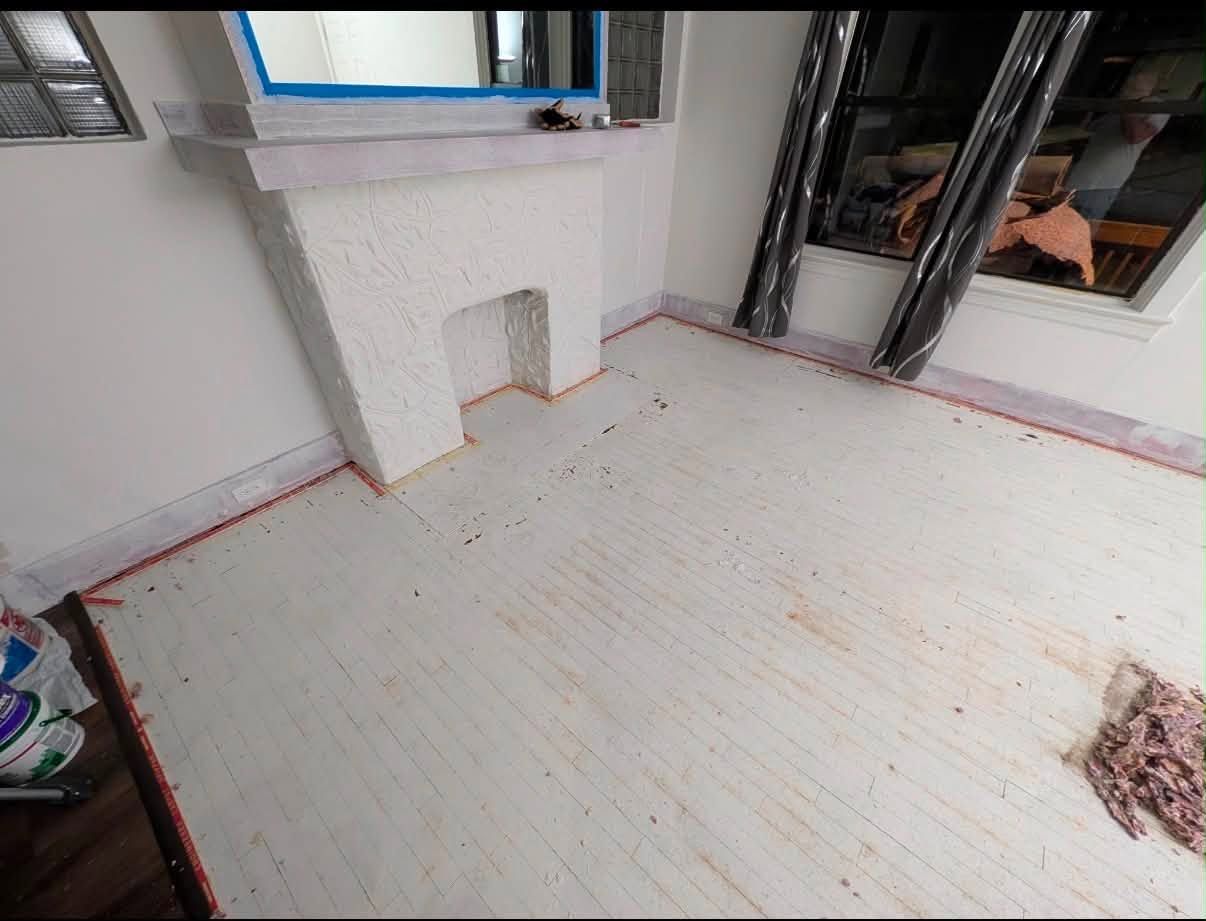 Empty room with white floors, windows, and exposed walls under renovation