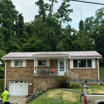 Brick house with white trim, front porch, and a person in a neon shirt near the driveway