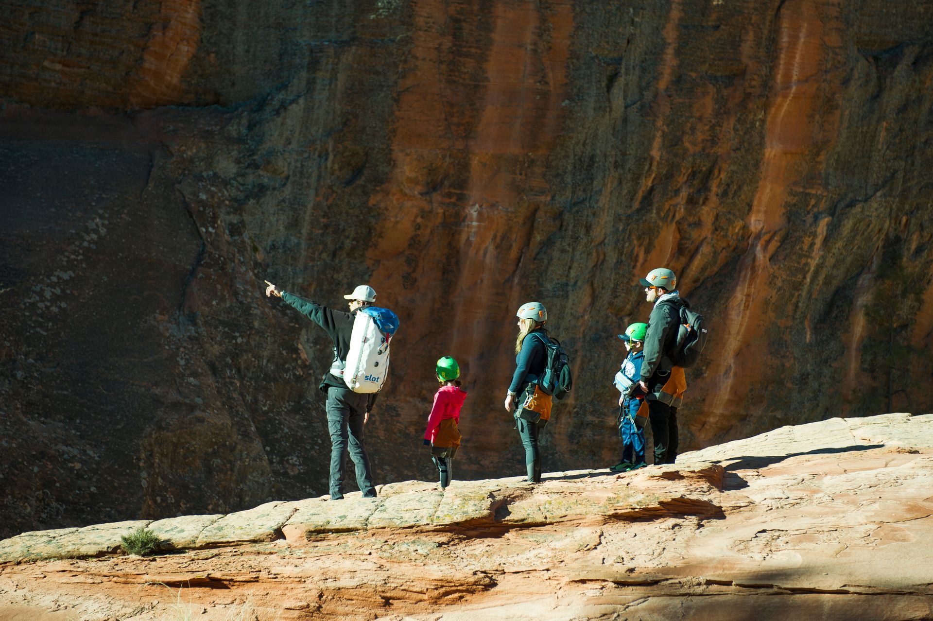 A group of people are standing on top of a rocky cliff.