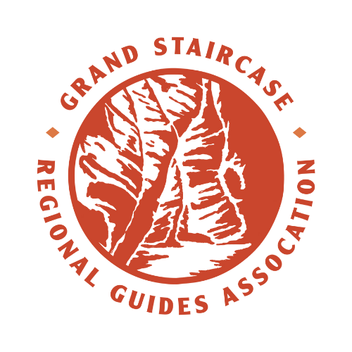 Logo for the Grand Staircase Regional Guides Association featuring a white canyon image on a red circle.