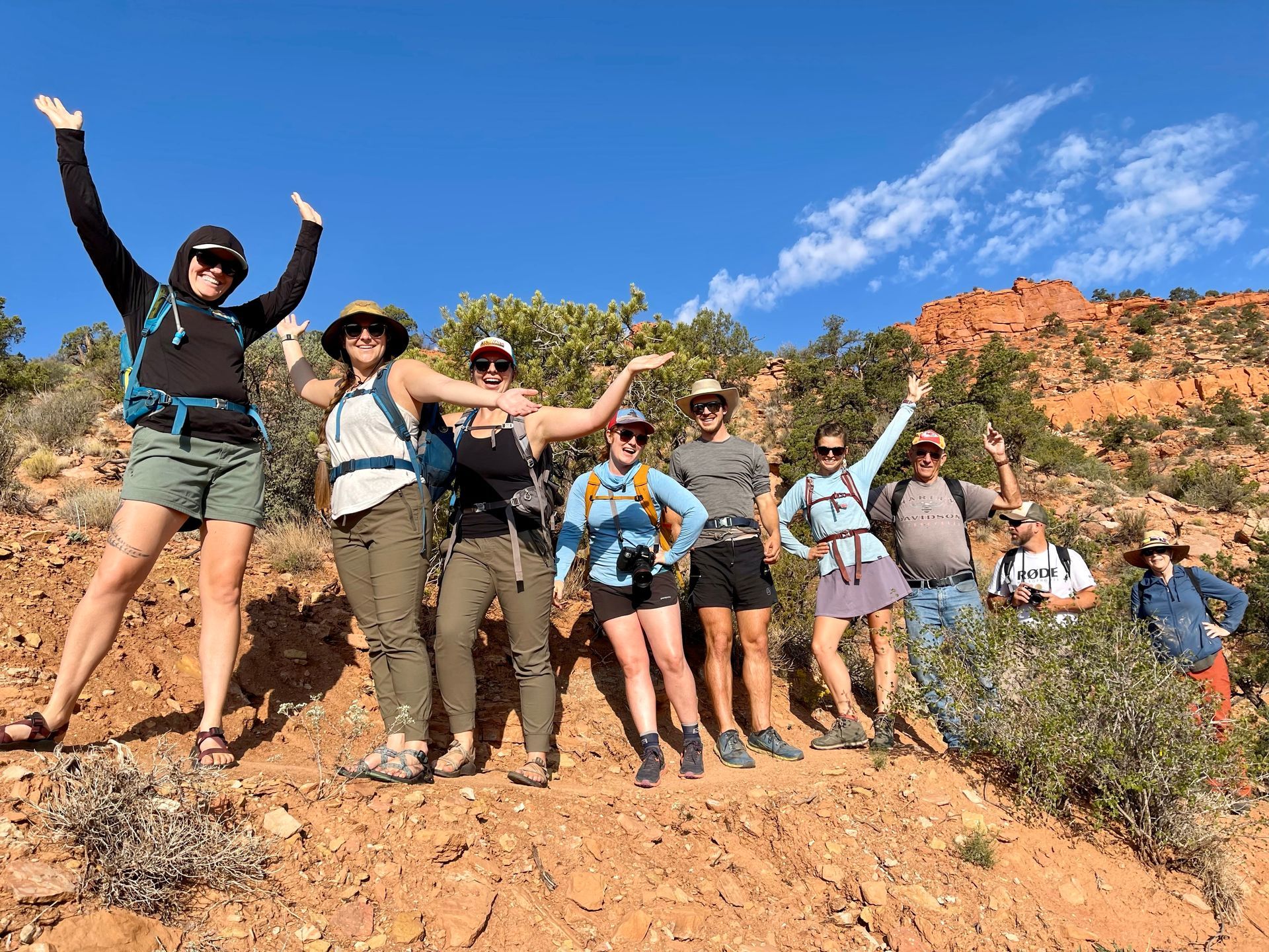 A group of people posing for a picture with their arms in the air