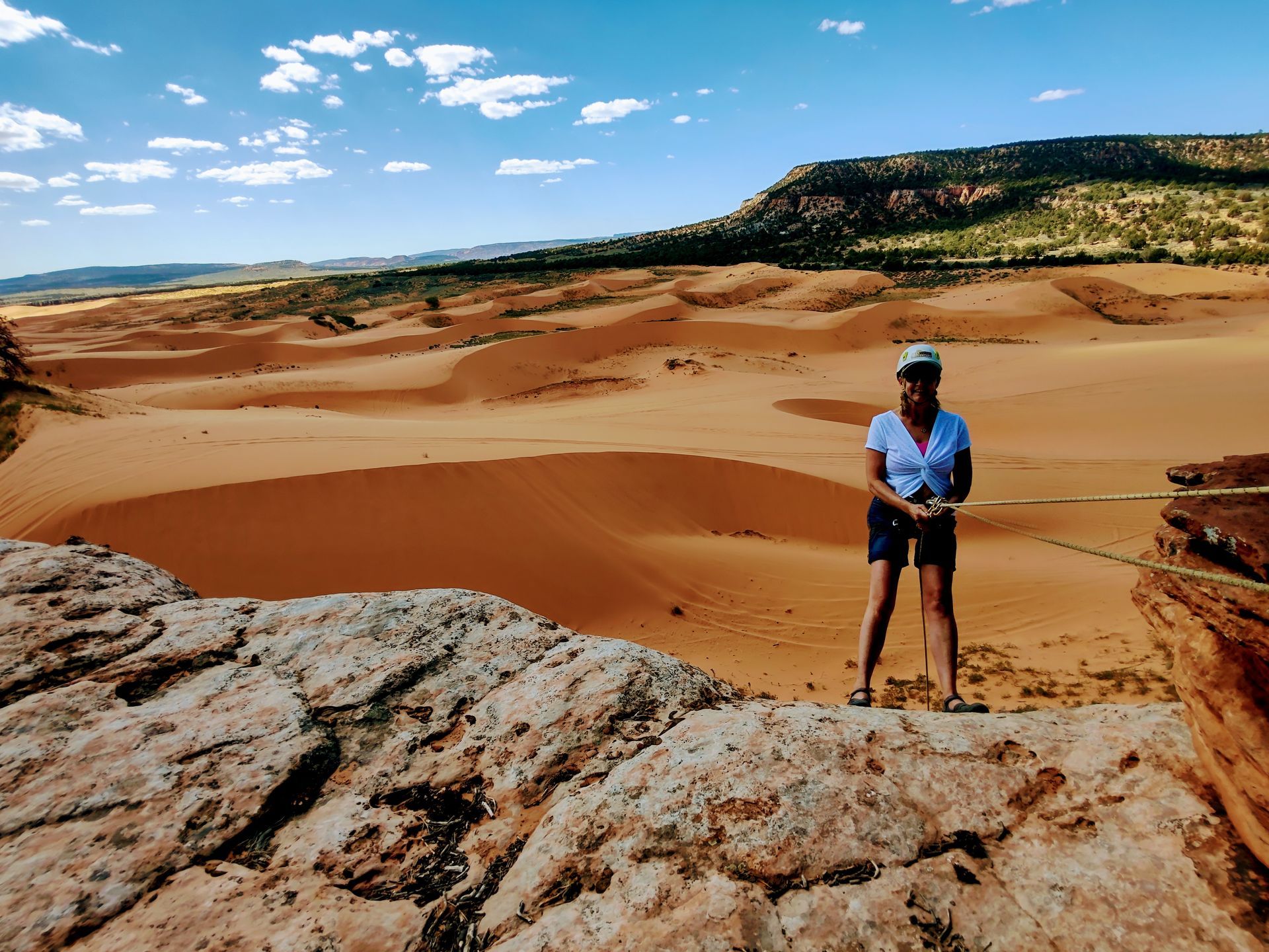 A woman standing on top of a rock in the desert