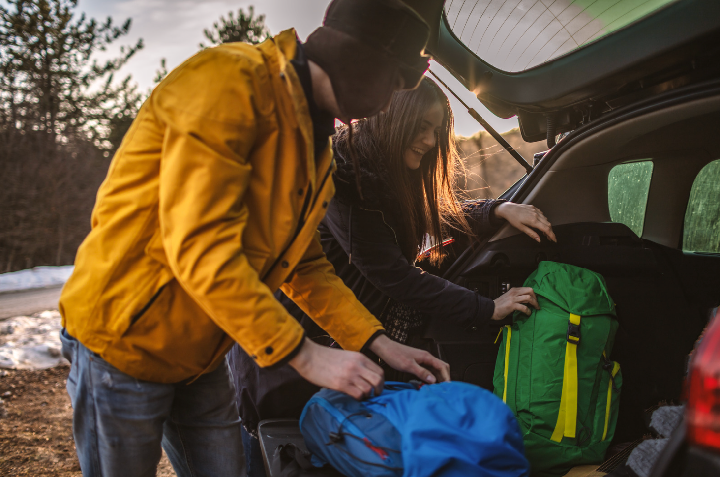 a woman and a man packing a car