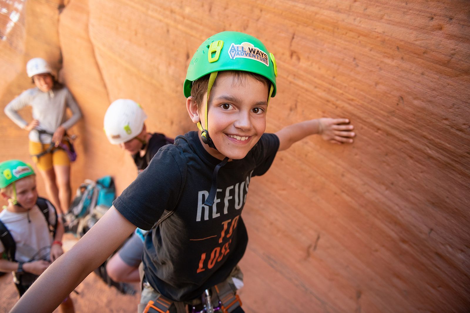 A young boy wearing a green helmet smilling