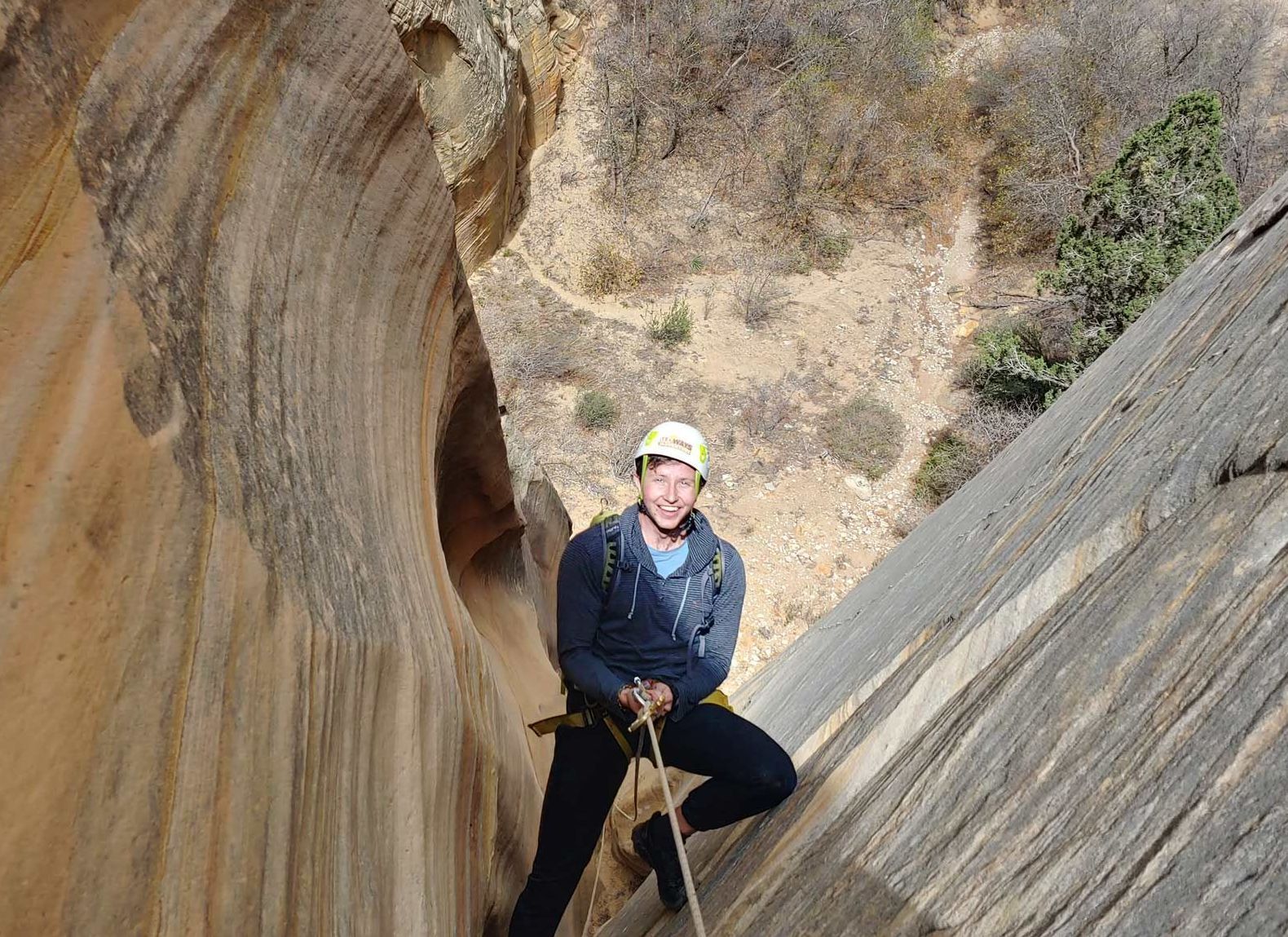 A person rapells down a canyon wall