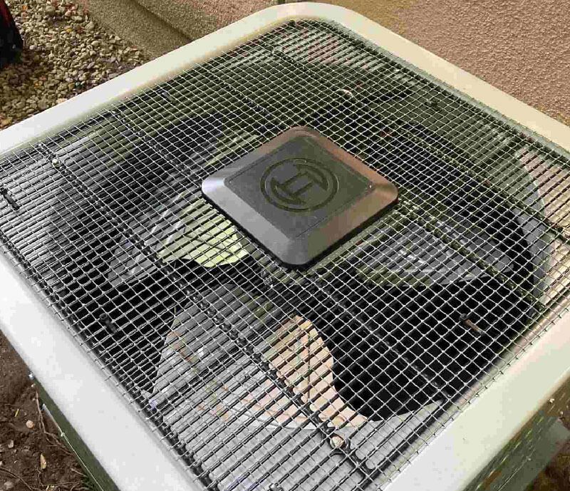A close up of an air conditioner with a mesh cover on it.