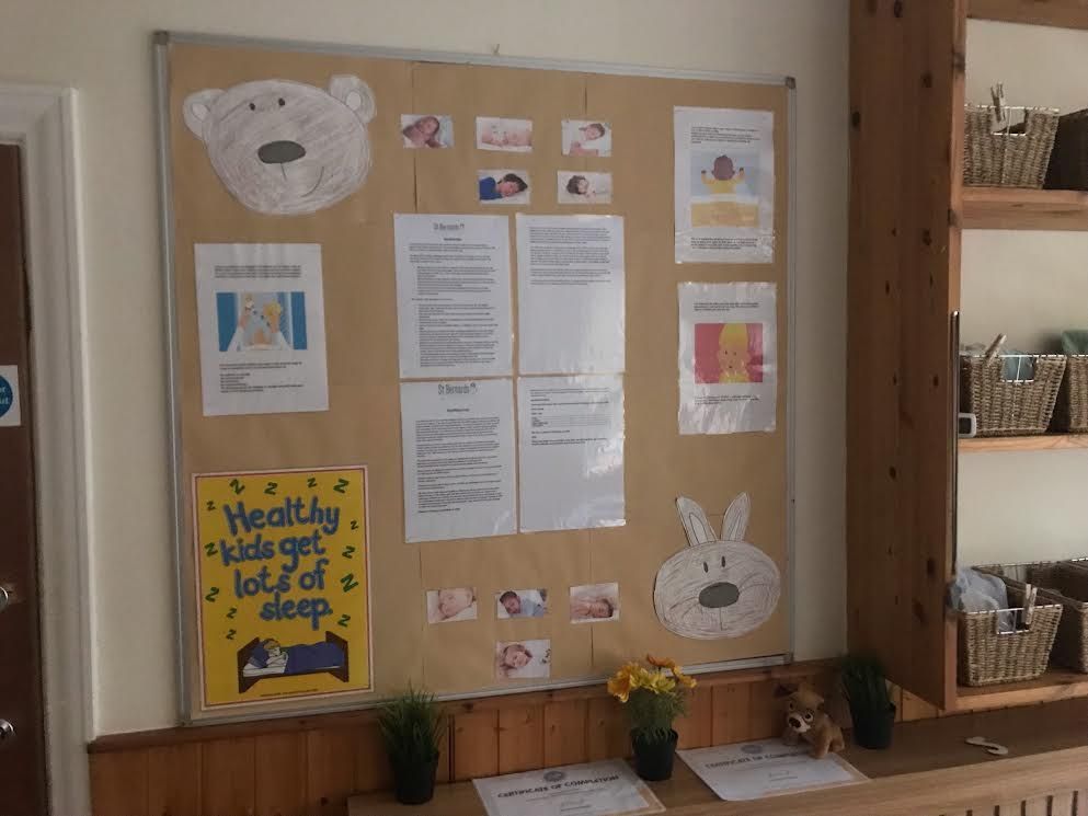Bulletin board with bunny decorations, posted notices, and a yellow “Healthy snack” sign in a wooden room.