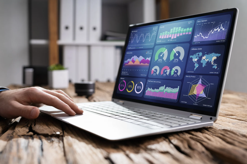 A person is using a laptop computer with a dashboard on the screen.