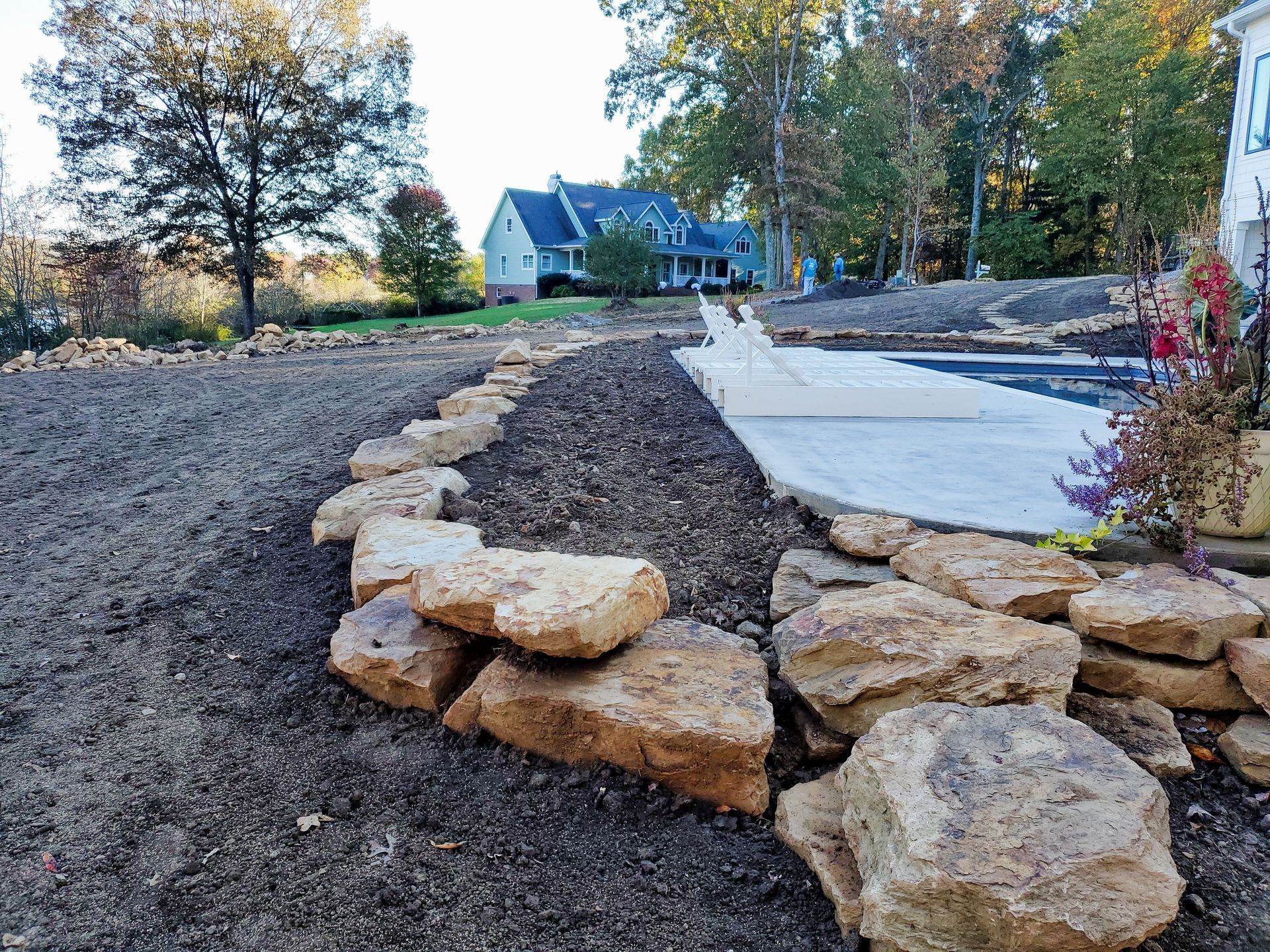 A row of rocks in a yard with a house in the background.