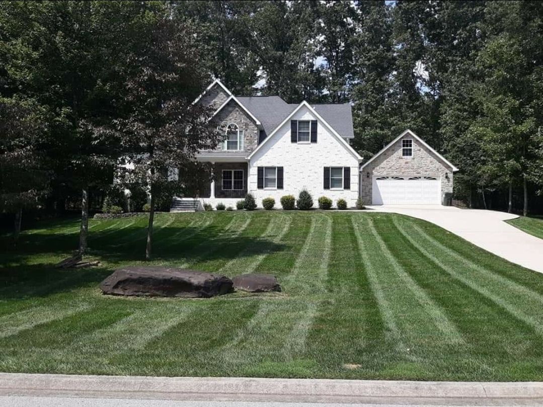 A white house with a lush green lawn in front of it