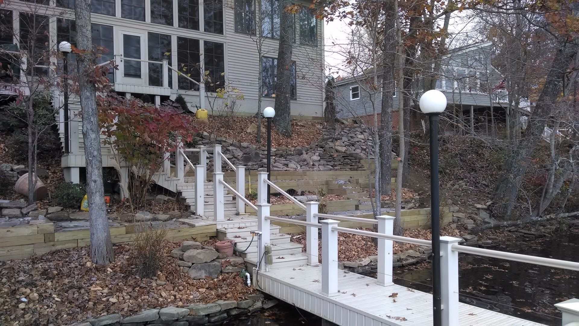 There is a dock leading to a house in the background.