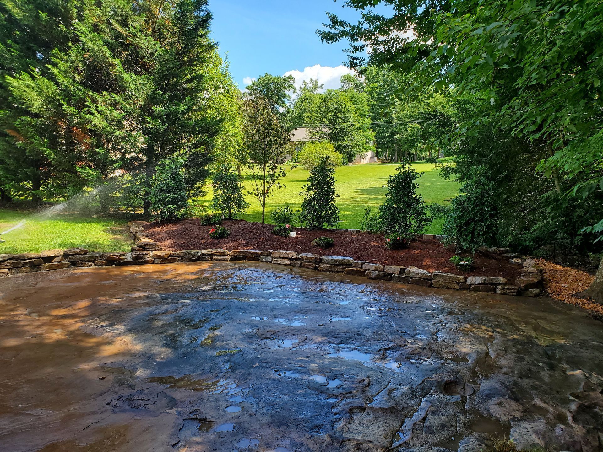 There is a large rock formation in the middle of the yard.