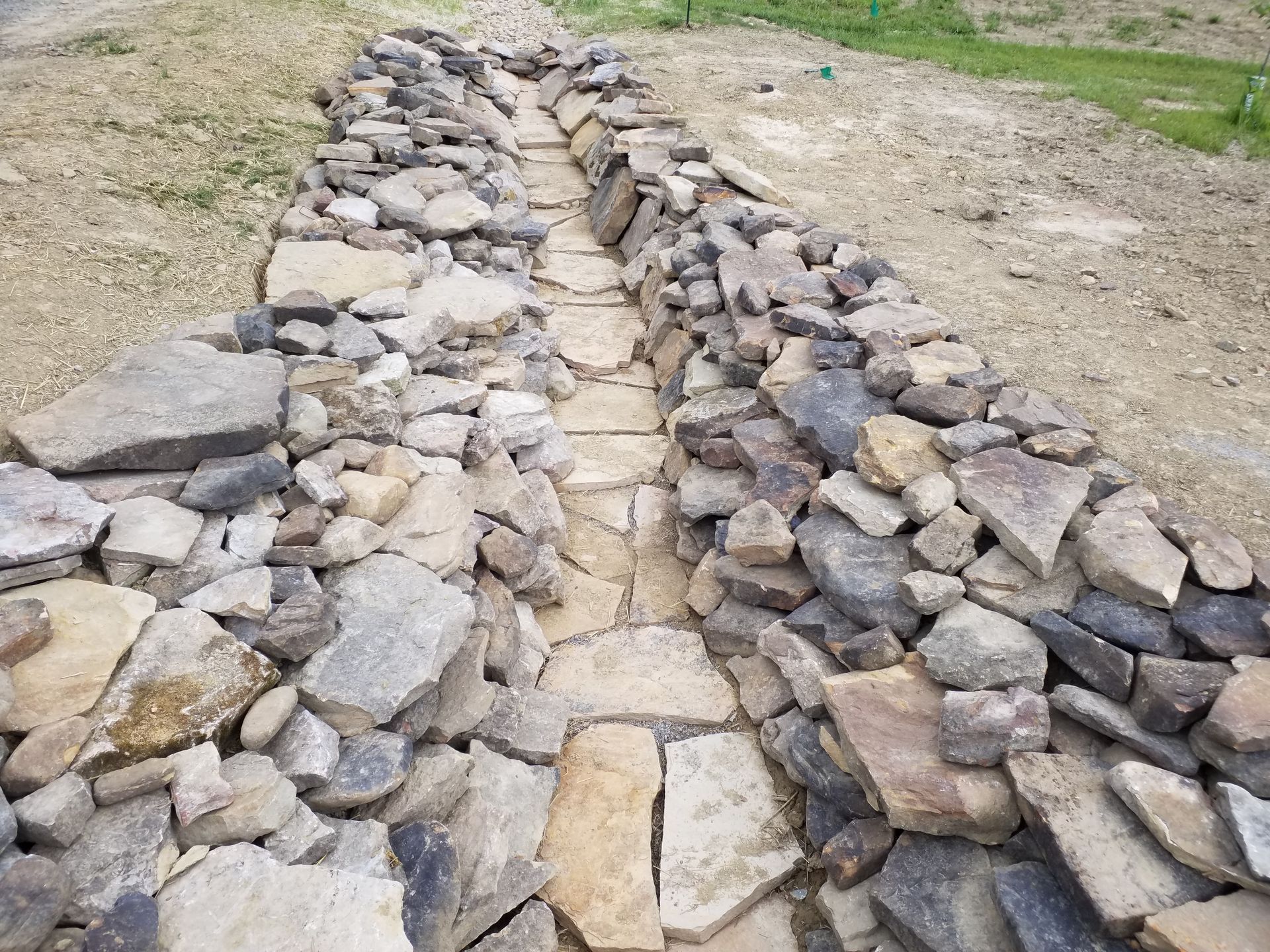 A stone walkway with a path going through it
