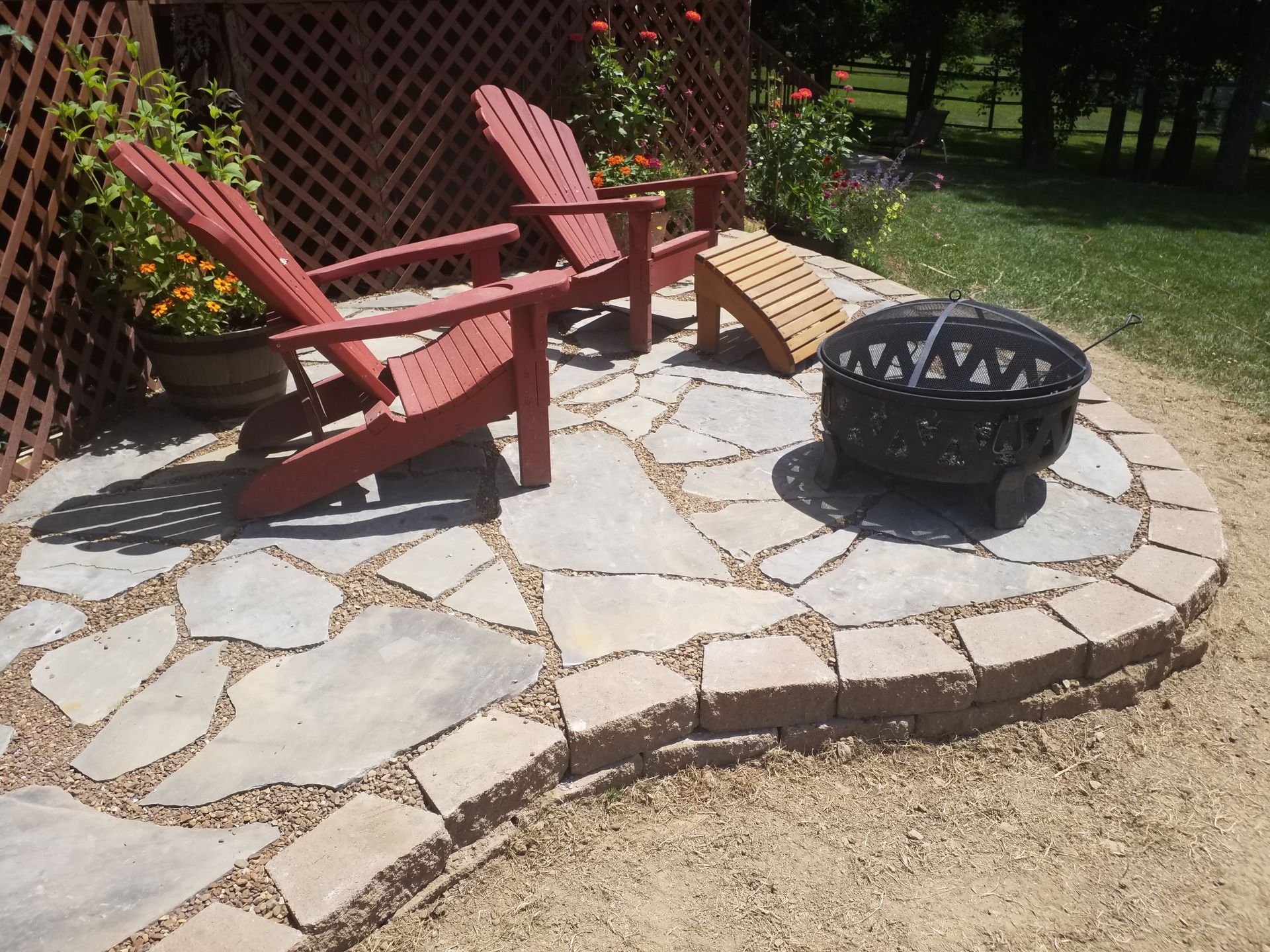 A fire pit sits in the middle of a stone patio