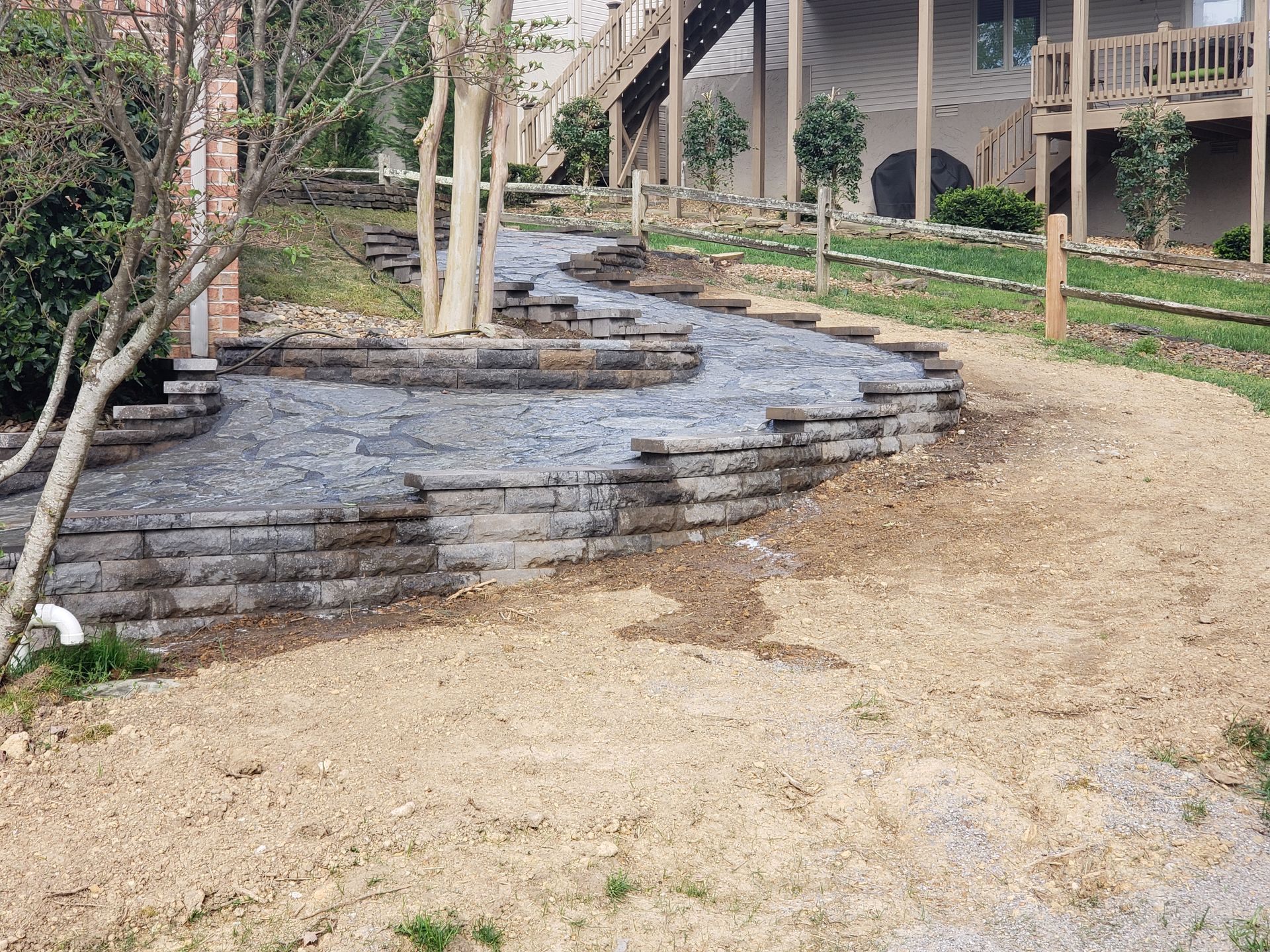 A stone walkway is being built in front of a house.