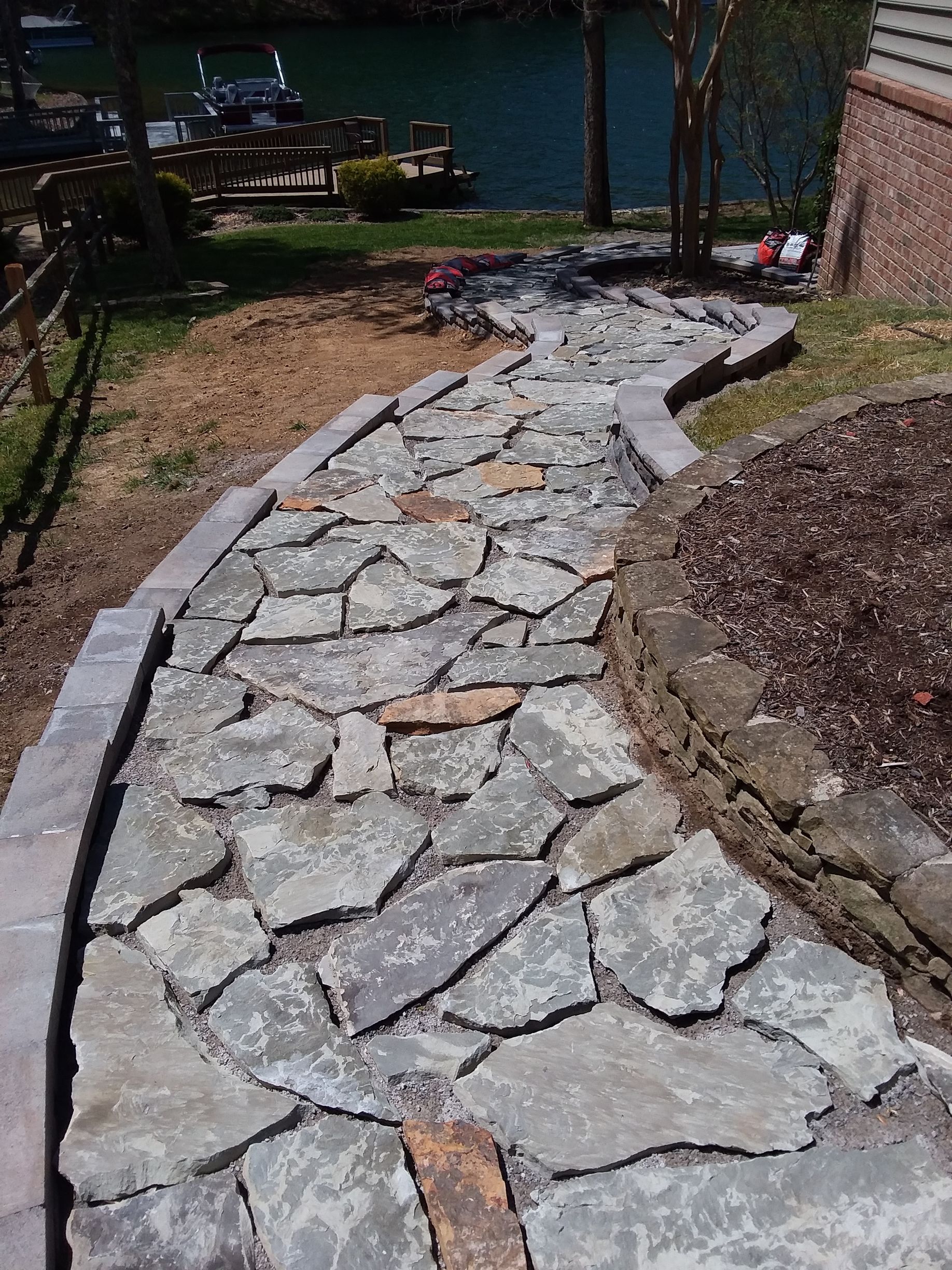 A stone walkway leading to a body of water.