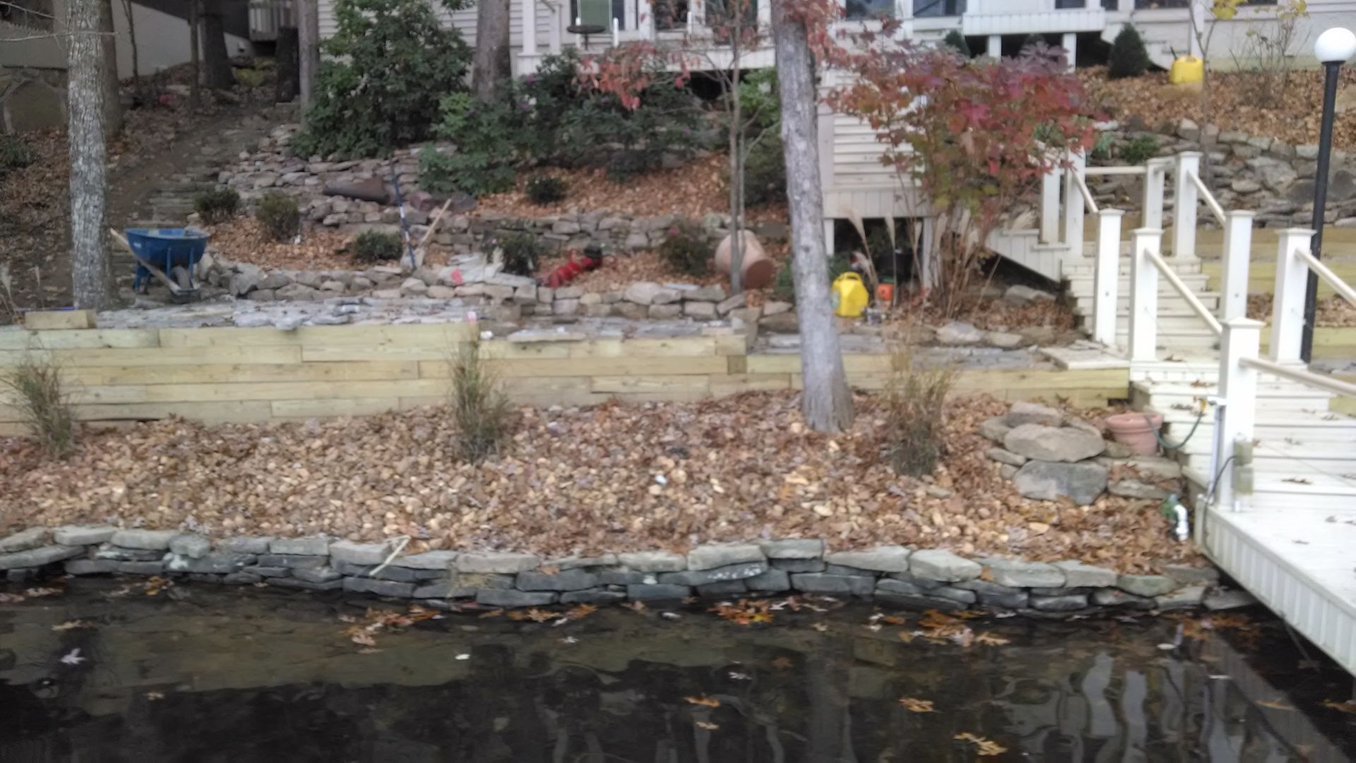 A dock with a house in the background and a pond in the foreground.