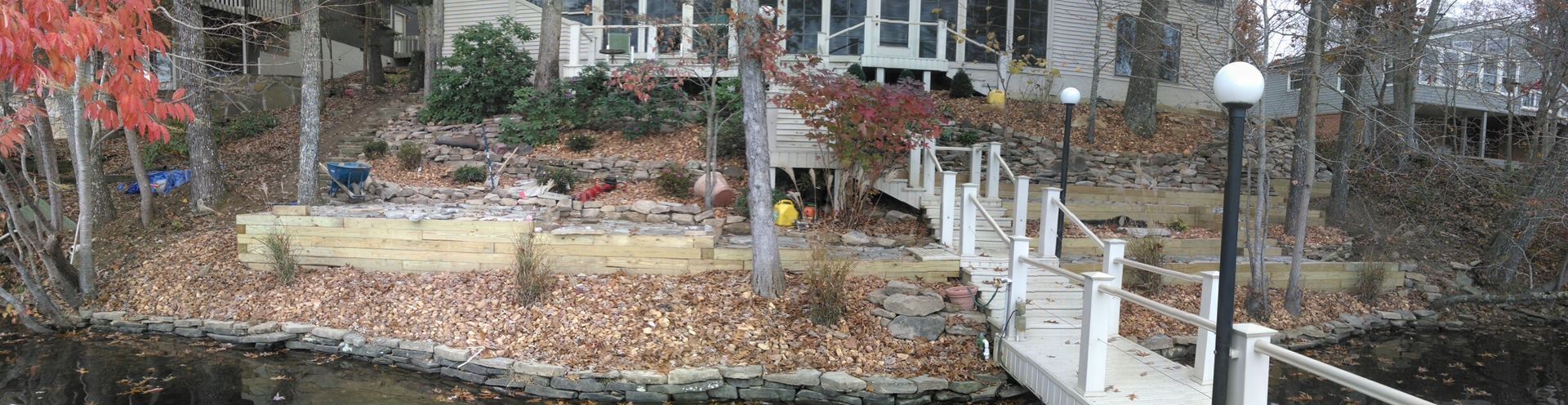 There is a dock in front of a house next to a body of water.