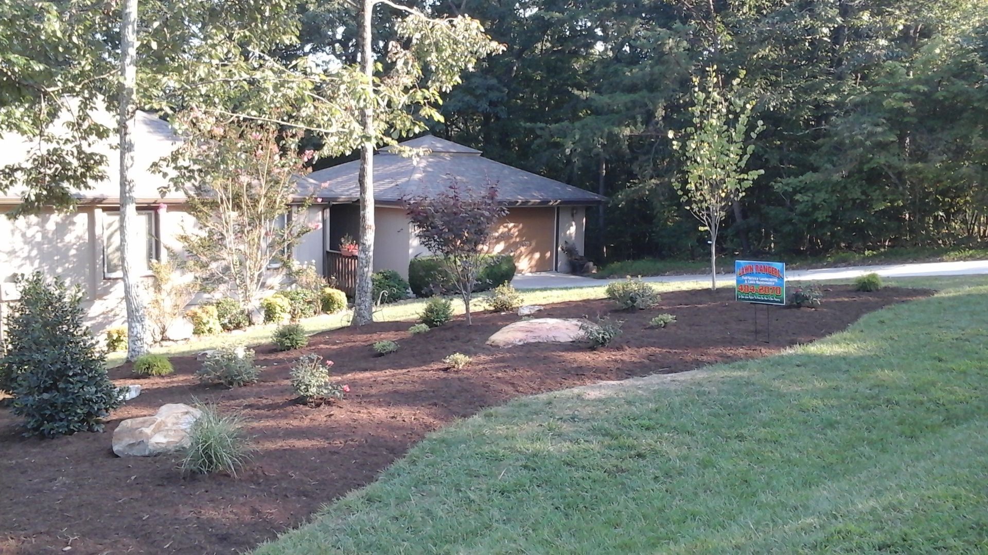 A house with a Lawn Rangers promotional sign in front of it
