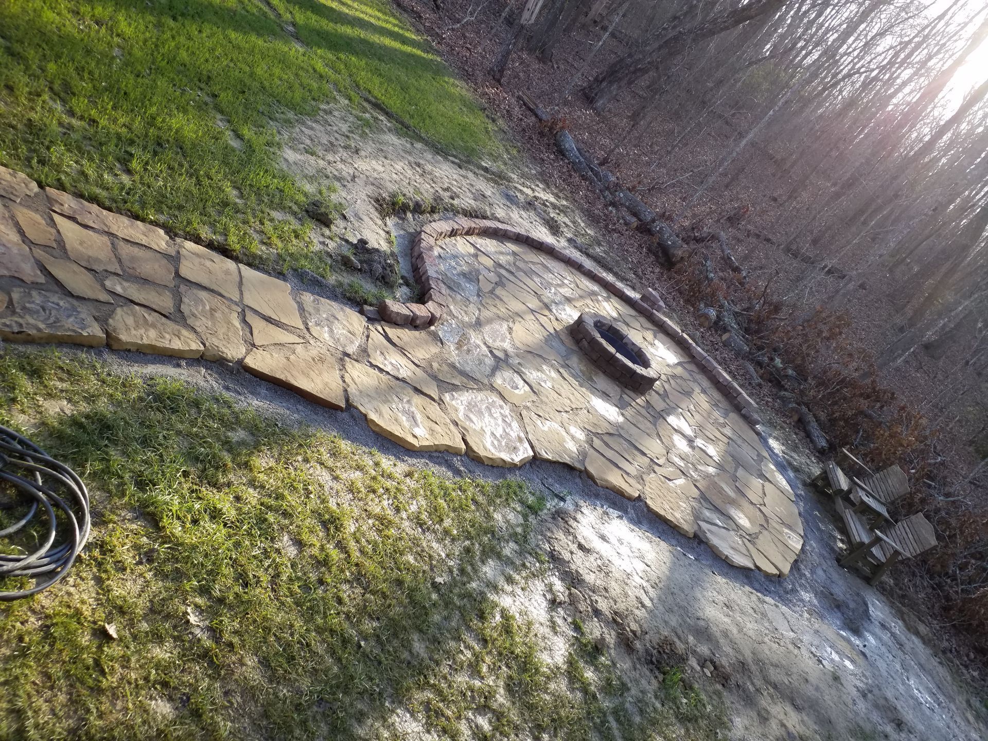 A stone walkway with a fire pit in the middle of it.