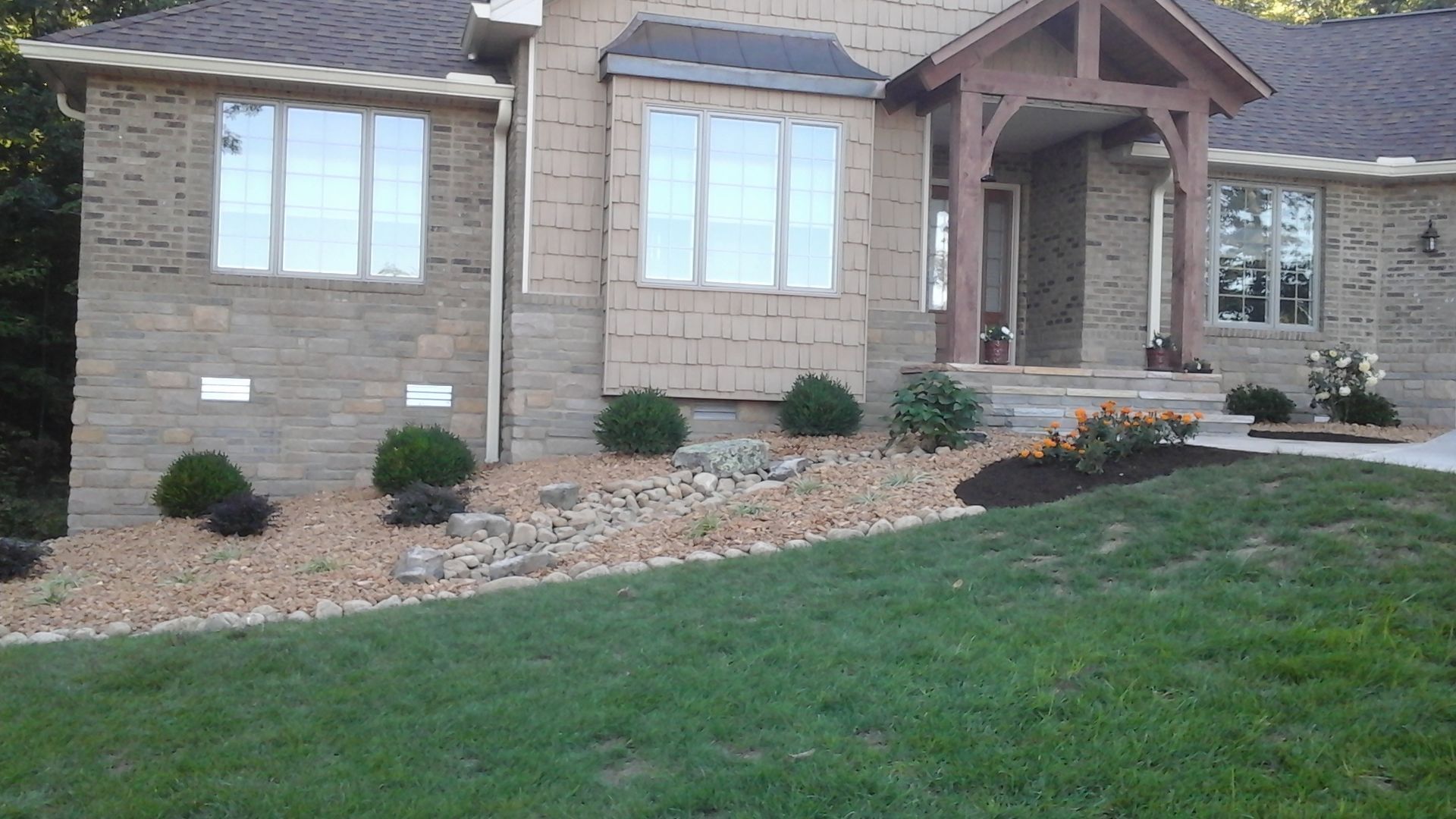 A brick house with a large lawn in front of it