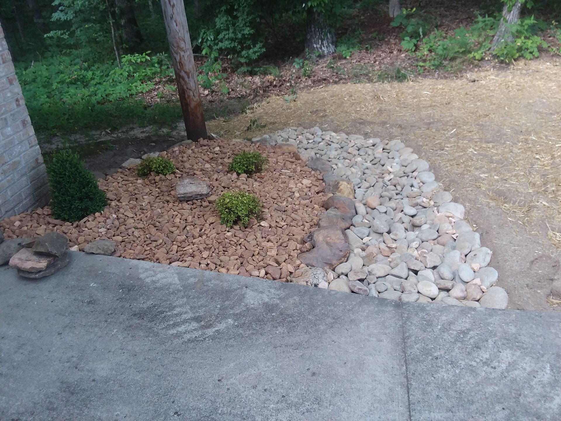 A garden with rocks and mulch in the middle of it