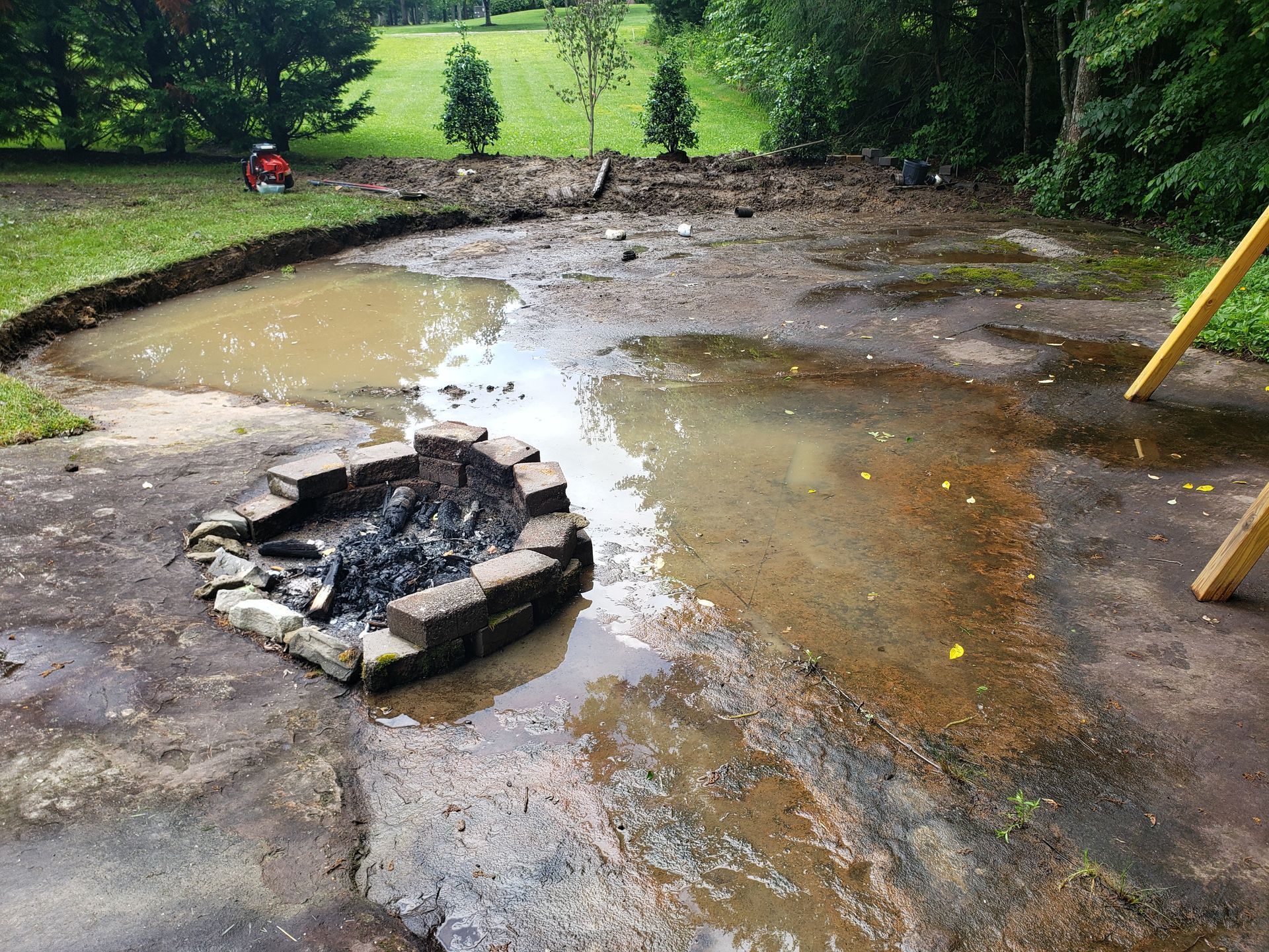 A muddy area with a fire pit in the middle of it.