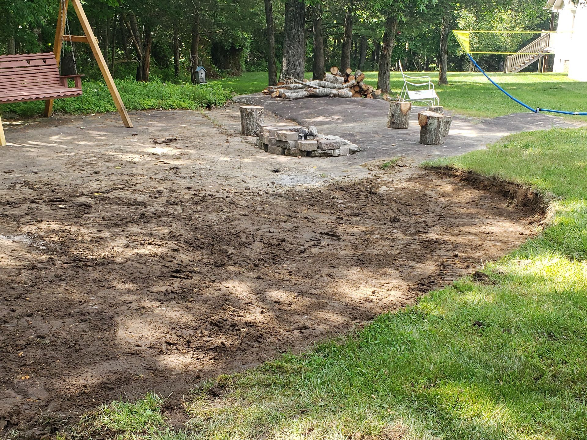 A muddy area in a park with a swing set in the background