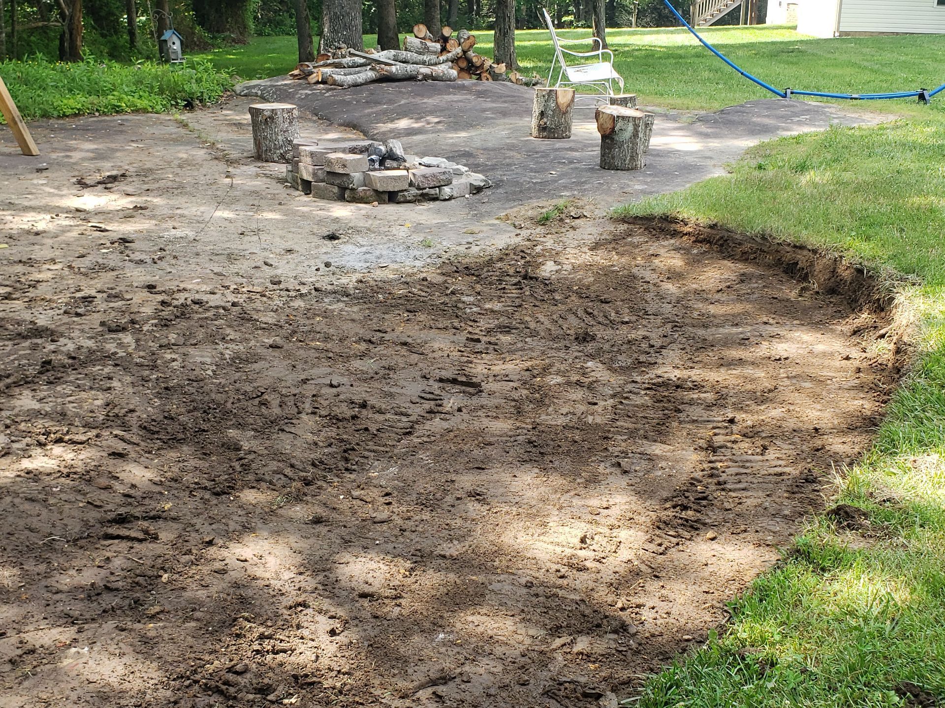 A muddy area with a fire pit in the middle of it.