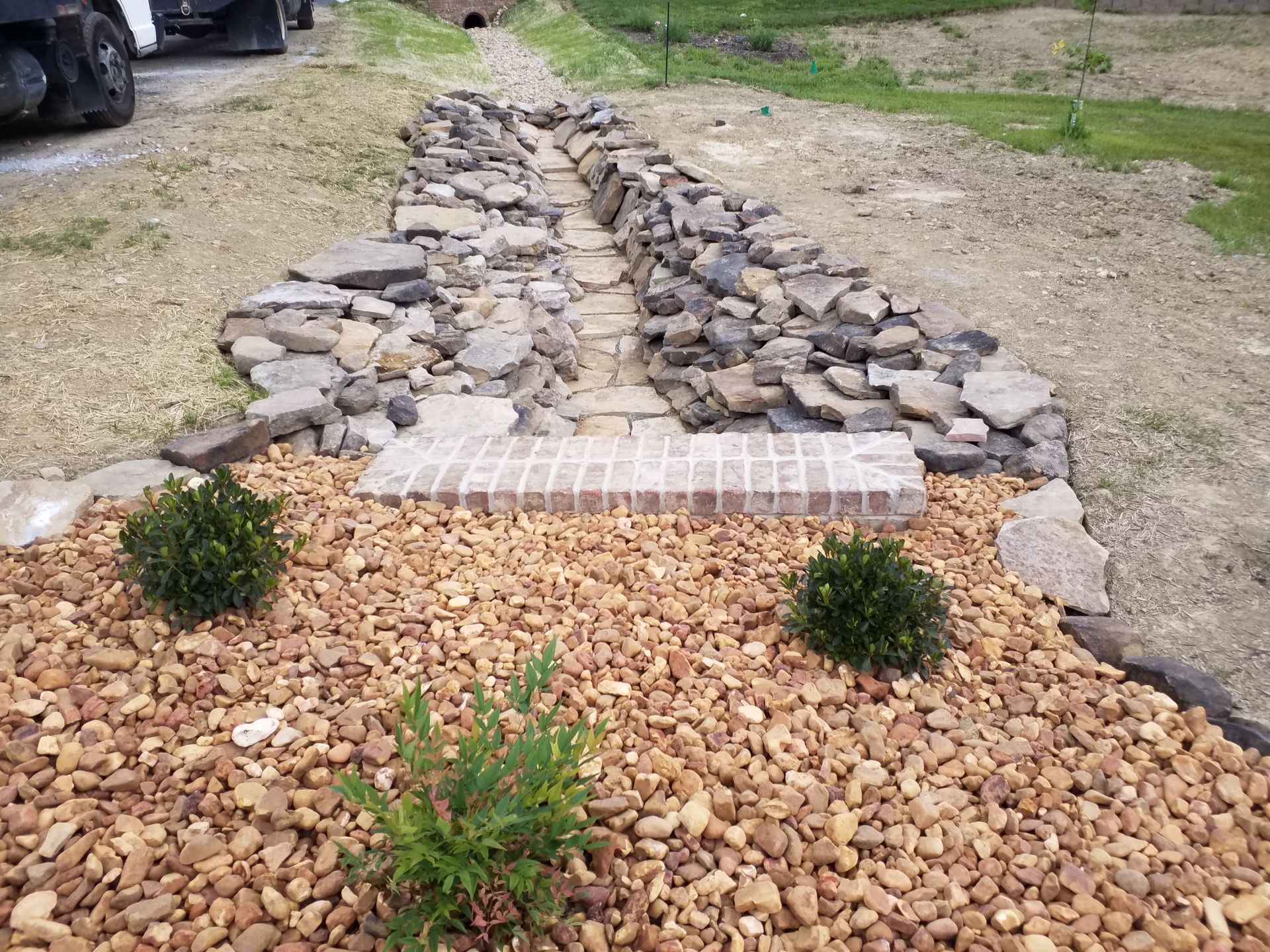 A gravel path is being built in the middle of a field.