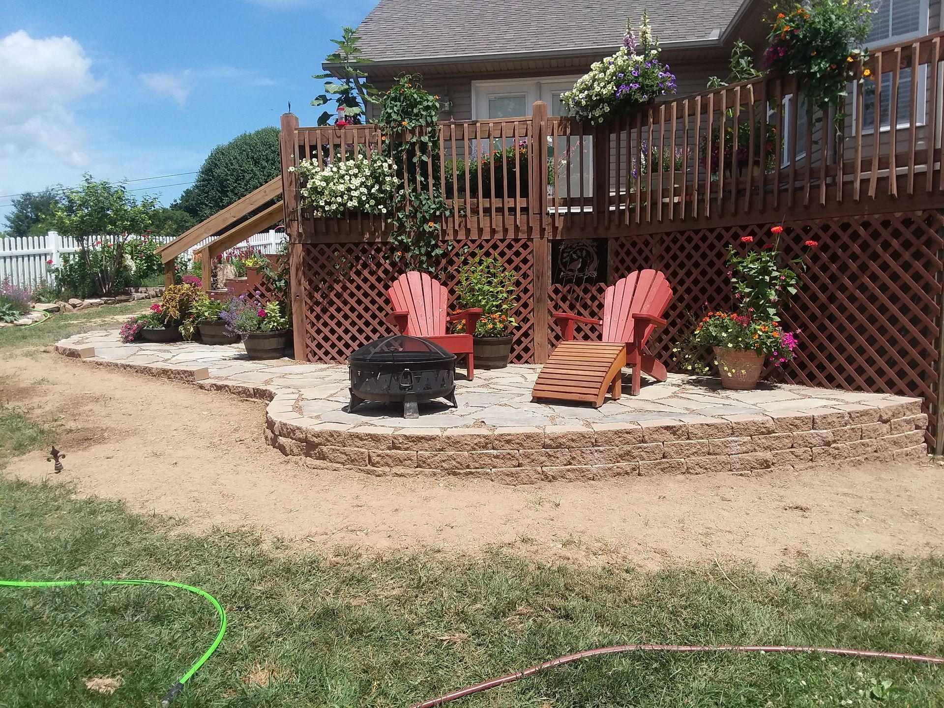 A patio with chairs and a fire pit in front of a house