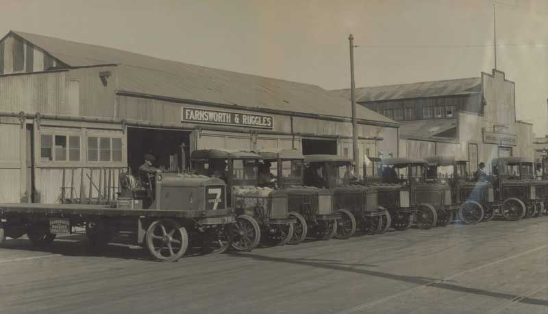A Black and White Photo of a row of Old Trucks Parked in front of a Building | San Rafael, CA | Earl Farnsworth Express