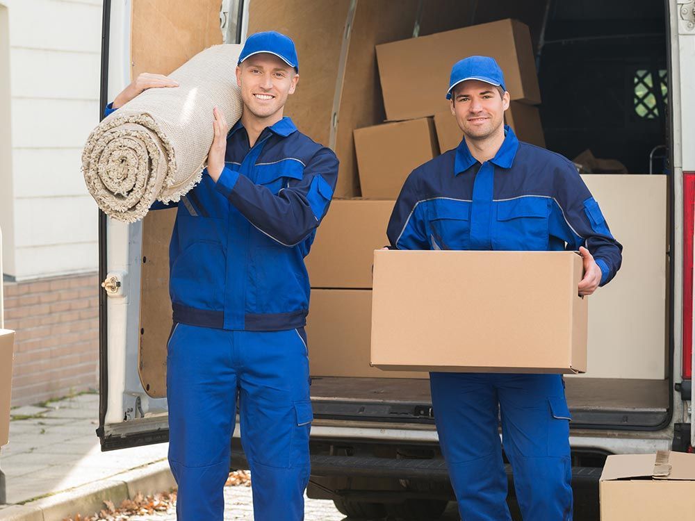Two men in blue uniforms carefully moving boxes as professional movers in Santa Venetia, CA. Two men in blue uniforms carefully moving boxes as professional movers in Santa Venetia, CA.
