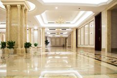 A long hallway with marble floors and columns in a building.