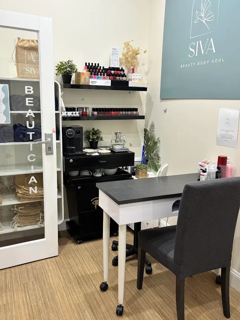 Nail salon interior with a manicure station, shelves of polish, and a 
