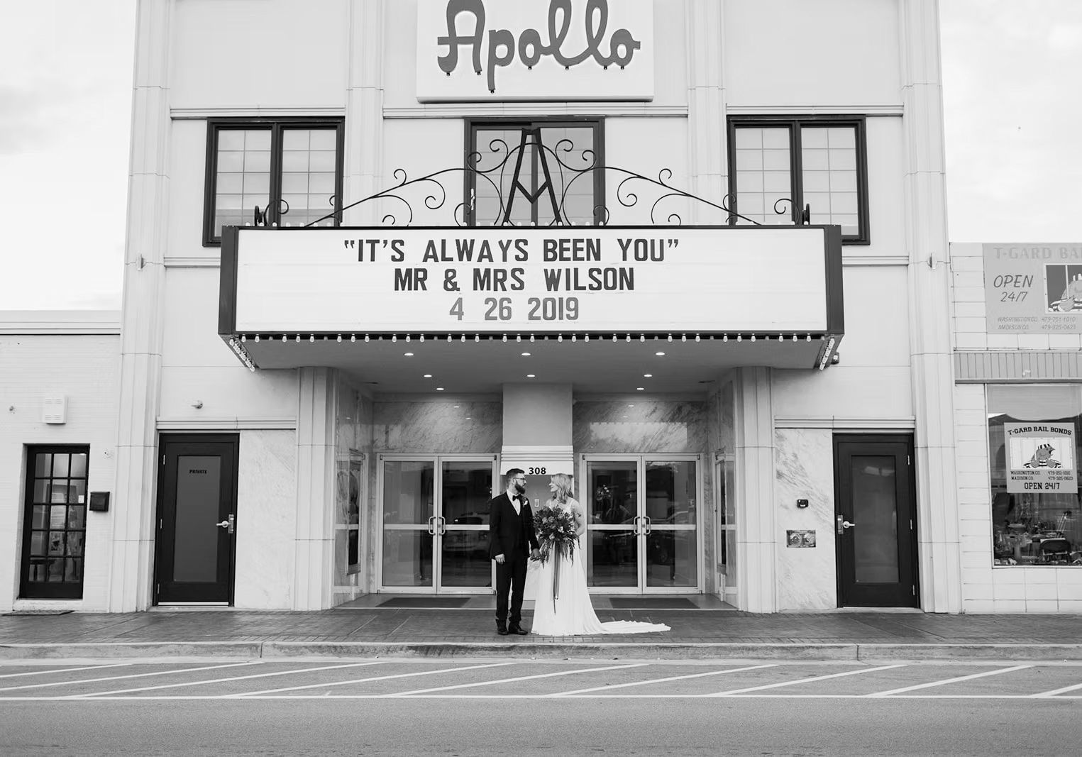Couple stands outside Apollo Theater with marquee reading