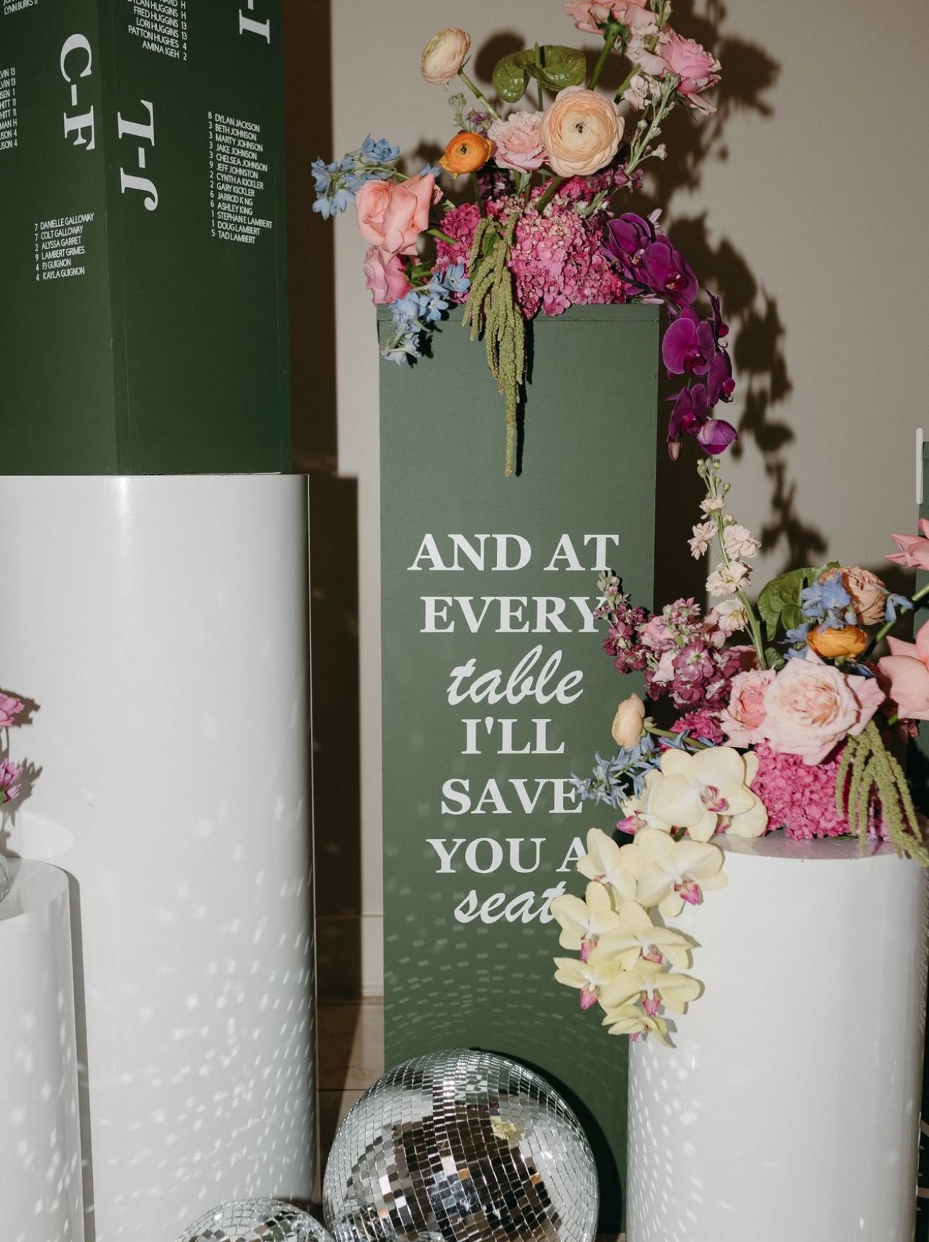 Floral arrangement atop green sign reading