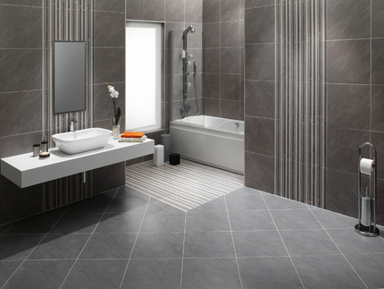 Modern gray bathroom with floating sink, bathtub, and patterned tile floor.