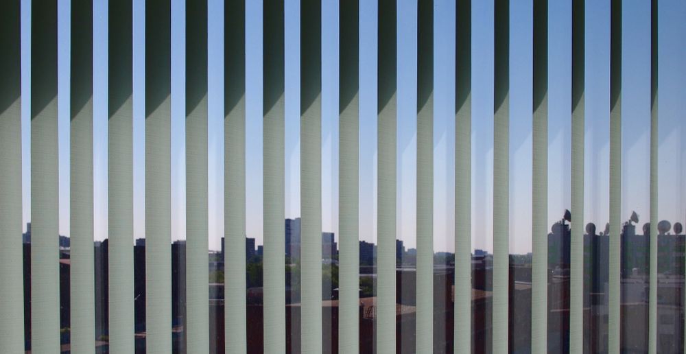 A View Of A City Skyline Through Vertical Blinds — Queanbeyan Carpets in Queanbeyan, NSW