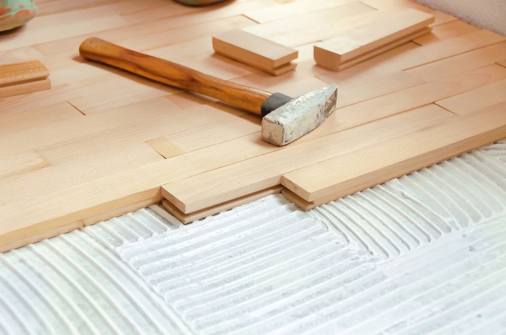 A Hammer Is Paced On Top Of A Wooden Floor — Queanbeyan Carpets in Queanbeyan, NSW