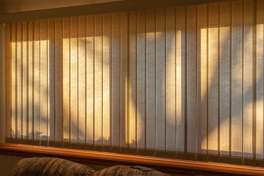 The Sun Is Shining Through The Vertical Blinds On The Window — Queanbeyan Carpets in Bungendore, NSW